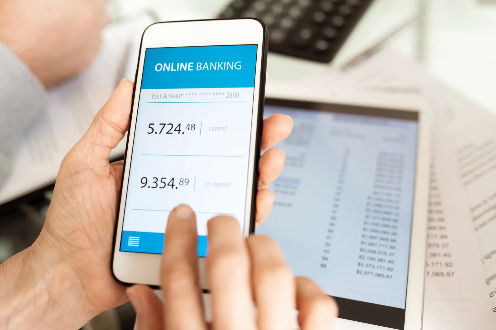 Smartphone affichant une application bancaire pro avec solde, dernières transactions et boutons de virement SEPA