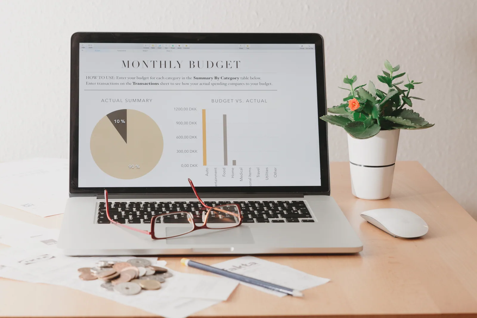 Tableau de bord d'un freelance qui suit son budget logiciels et abonnements pro sur tableur, post-its et café