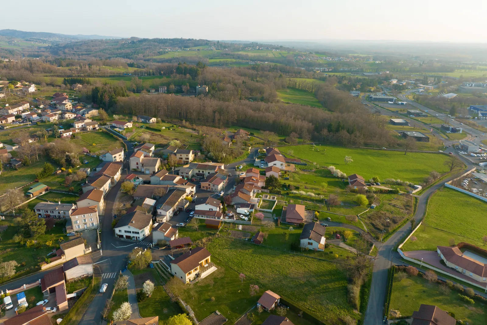 Vue aérienne d'un village rural français entouré de prairies, exemple typique du tissu démographique béarnais où l'accès aux soins de kiné se joue à 20 km de route